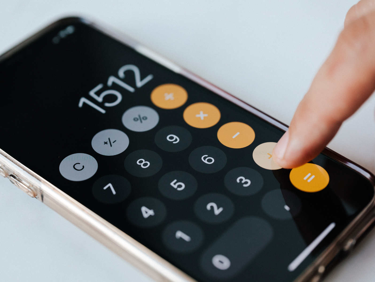 Finger trykker på lommeregner på Iphone