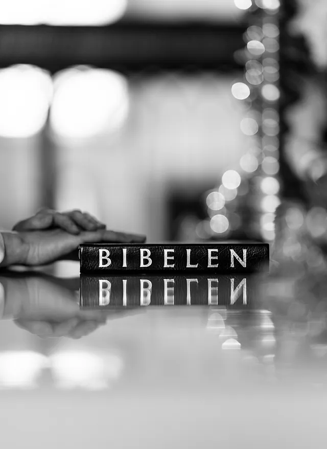 Præst med hænderne på en Bibel